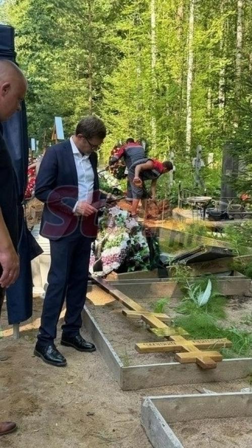 Максим сырников: деревянный крест, алые цветы и корчевников, вглядывающийся в портрет. 01